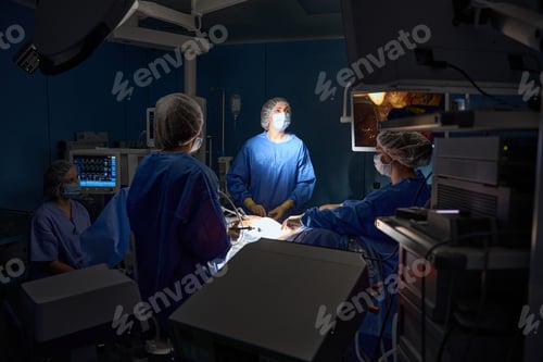 Preview: Doctors in protective masks doing operation in the operating room in hospital