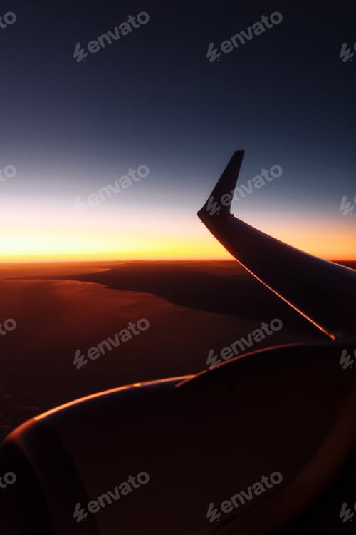 Preview: Beautiful view from airplane window on the wing at sunset or sunrise time. Flying above the clouds.