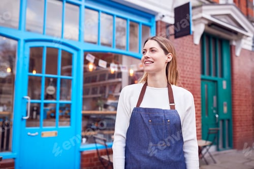 Preview: Portrait Of Smiling Female Small Business Owner Standing Outside Shop On Local High Street