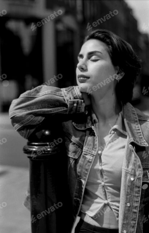 Preview: Young woman leaning on a pole in black and white analog photo