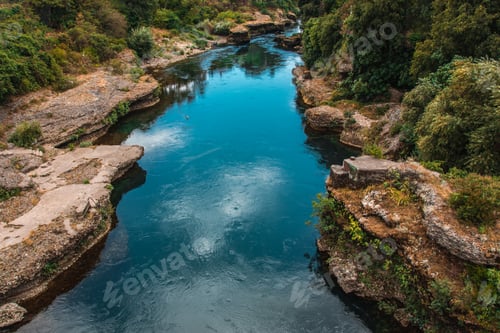 Preview: Beautiful view of the water surrounded by rocks, stones, trees, plants on a sunny day