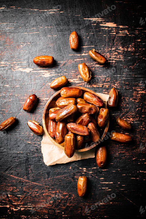 Preview: Delicious dates on a wooden plate.