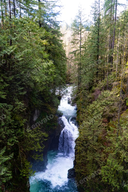 Preview: Scenic view of waterfall on rough river in tropical forest valley on sunny day