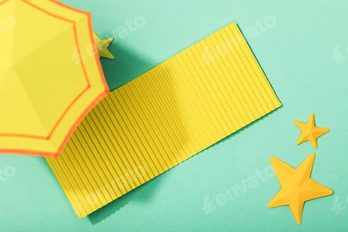 Preview: top view of paper cut yellow towel and umbrella near starfishes on turquoise background