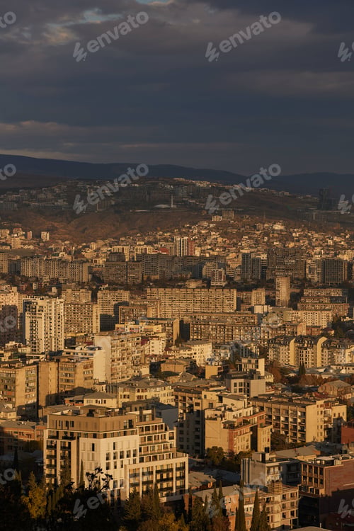 Preview: Scenic view of Tbilisi surrounded by majestic mountains in the distance at sunrise in Georgia