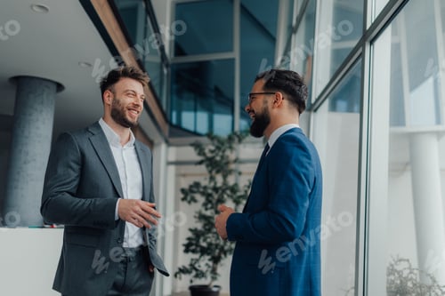 Preview: Two businessmen having a friendly conversation in modern office