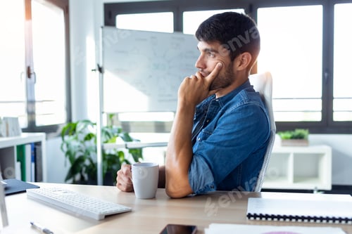Preview: Software developer thinking in new project while working with computer in the modern startup office.