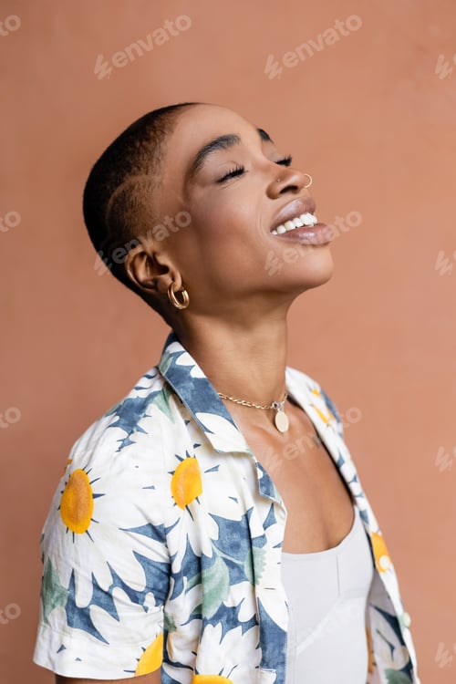 Preview: Portrait of joyful and stylish african american woman closing eyes outdoors
