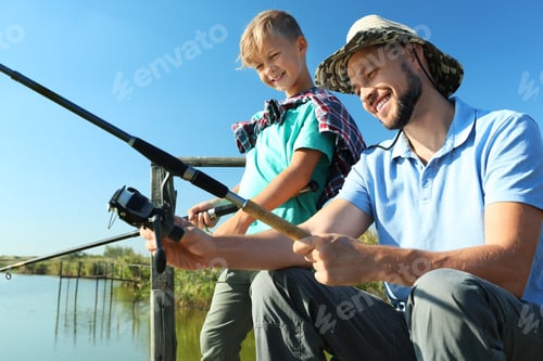 Preview: Father and son fishing together on sunny day