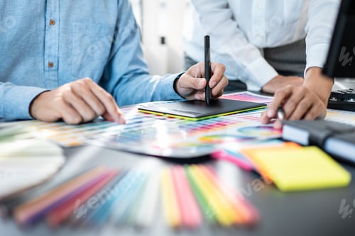 Preview: Two creative graphic designer team working on color selection and drawing on graphic tablet
