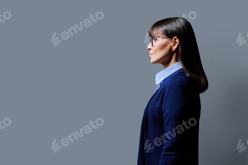 Preview: Profile portrait of mature confident serious woman on gray background