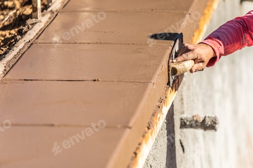 Preview: Construction Worker Using Stainless Steel Edger On Wet Cement Forming Coping Around New Pool