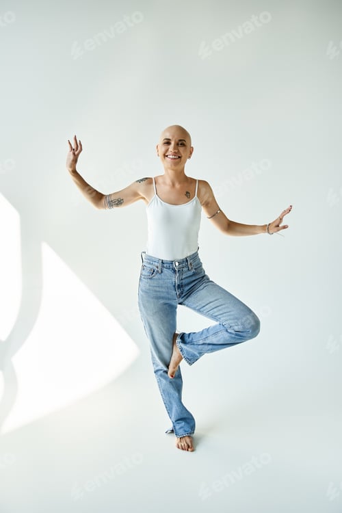 Preview: A graceful young bald woman with alopecia expresses joy in a serene studio setting
