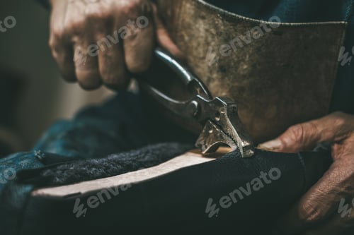 Preview: cropped shot of shoemaker pooling on leather on shoe with pliers