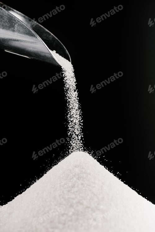 Preview: white sugar falling from metal scoop on pile isolated on black