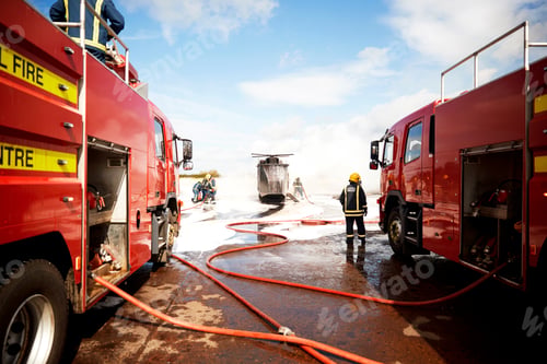 Preview: Firemen training, team of firemen spraying firefighting foam at mock helicopter at training facility
