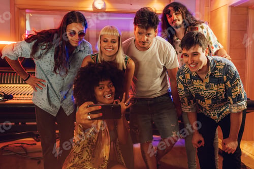 Preview: Band mates taking a photo portrait with music recording studio crew.
