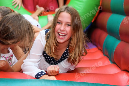 Preview: Cheerful Preteen Girl Laughing in Colorful Inflatable Bounce House