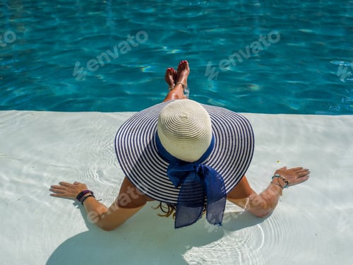 Preview: woman in luxury spa resort near the swimming pool.