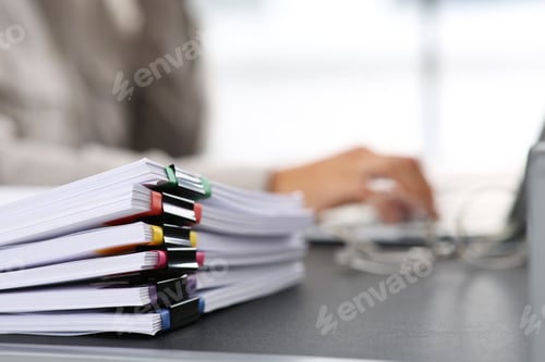 Preview: Businesswoman working with laptop at grey table in office, focus on documents. Space for text