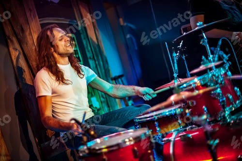 Preview: Drummer playing on drum set on stage.