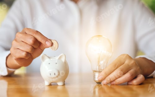 Preview: A woman holding light bulb while putting coins into piggy bank for saving money concept