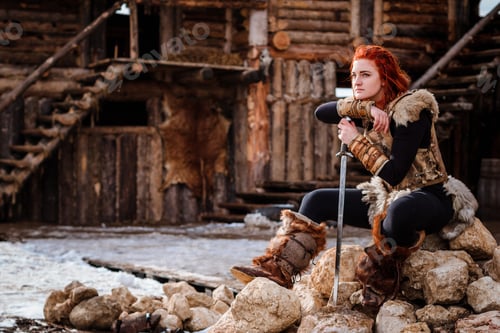 Preview: Red-haired woman is a Viking. Against backdrop of a village or an ancient settlement