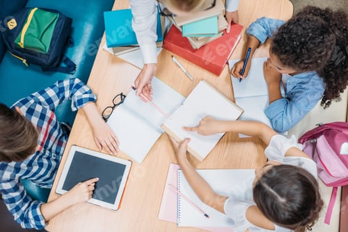 Preview: top view of teacher and pupils doing homework together