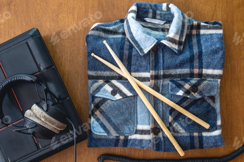 Preview: Drum Pad, Sticks, and Flannel on Wooden Surface