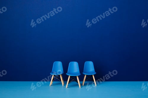 Preview: Three chairs against a blue wall. Business Concept
