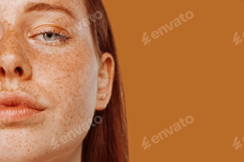 Preview: Close-up portrait of half face of a red-haired girl with freckle
