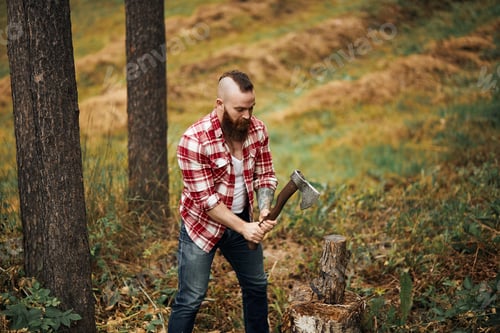 Preview: Woodcutter in shirt chopping firewoods, chips fly apart