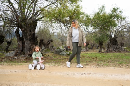Preview: Mother and child walking with balance bike in nature park