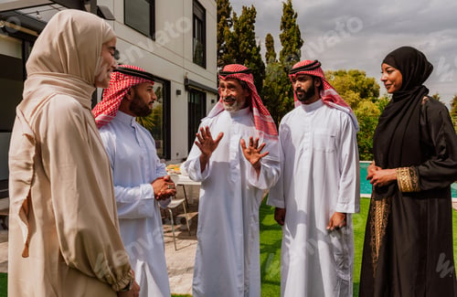 Preview: Arab multi-generational family gathering and discussing outdoors