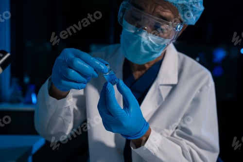 Preview: doctor or lab scientist holding glass ampoule vial