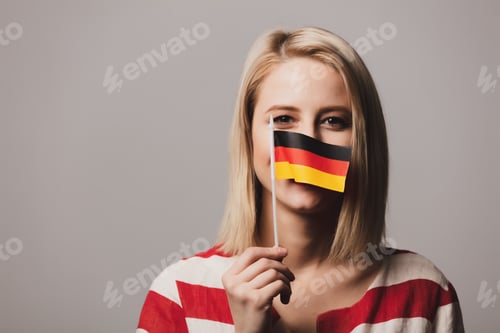 Preview: beatiful girl holds German flag on gray background