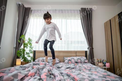 Preview: Cute little girl jumping on the bed
