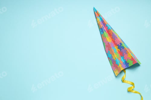 Preview: Paper plane with colorful puzzle pieces on light background, place for text