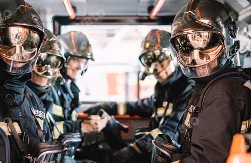 Preview: unrecognizable firemen with helmet in an emergency vehicle