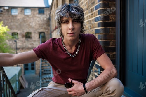 Preview: Androgynous female sitting on squat position looking at camera.