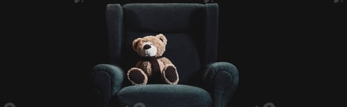 Preview: panoramic shot of teddy bear in grey armchair isolated on black