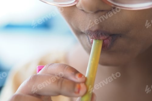 Preview: Child sipping sugarcane juice on a sunny day