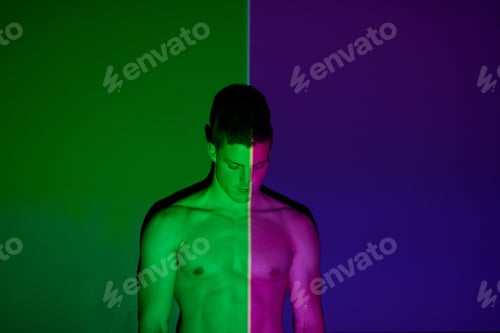 Preview: Theres two sides to all of us. Studio shot of a young man posing against abstract lighting.