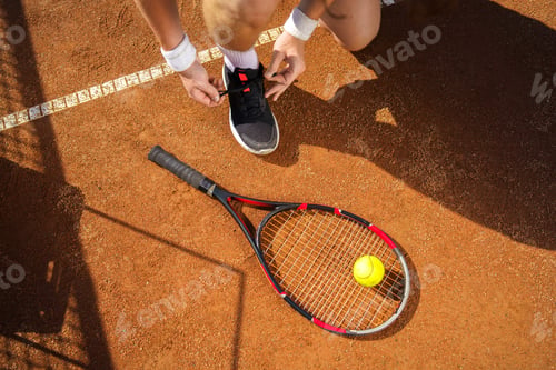 Preview: Tennis player tying his shoes