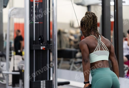 Preview: Determined african sportswoman lifting weights at the gym