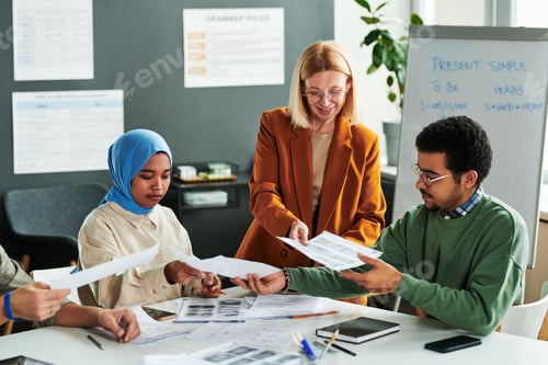 Preview: Group of students taking grammar tests while teacher passing papers to them