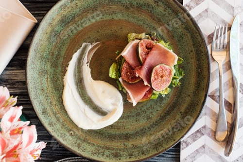 Preview: top view of delicious prosciutto with sauce and figs on plate