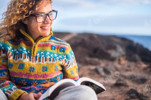 Preview: Woman sit down on the rocks in outdoor beautiful place with book
