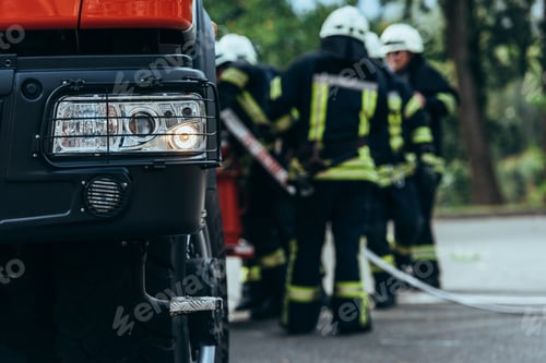 Preview: selective focus of firefighters brigade standing at fire truck on street