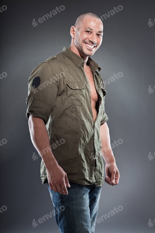 Preview: Muscled Tough Guy Wearing Green Army Shirt. Good Looking Man. Isolated On Grey Background. Studio
